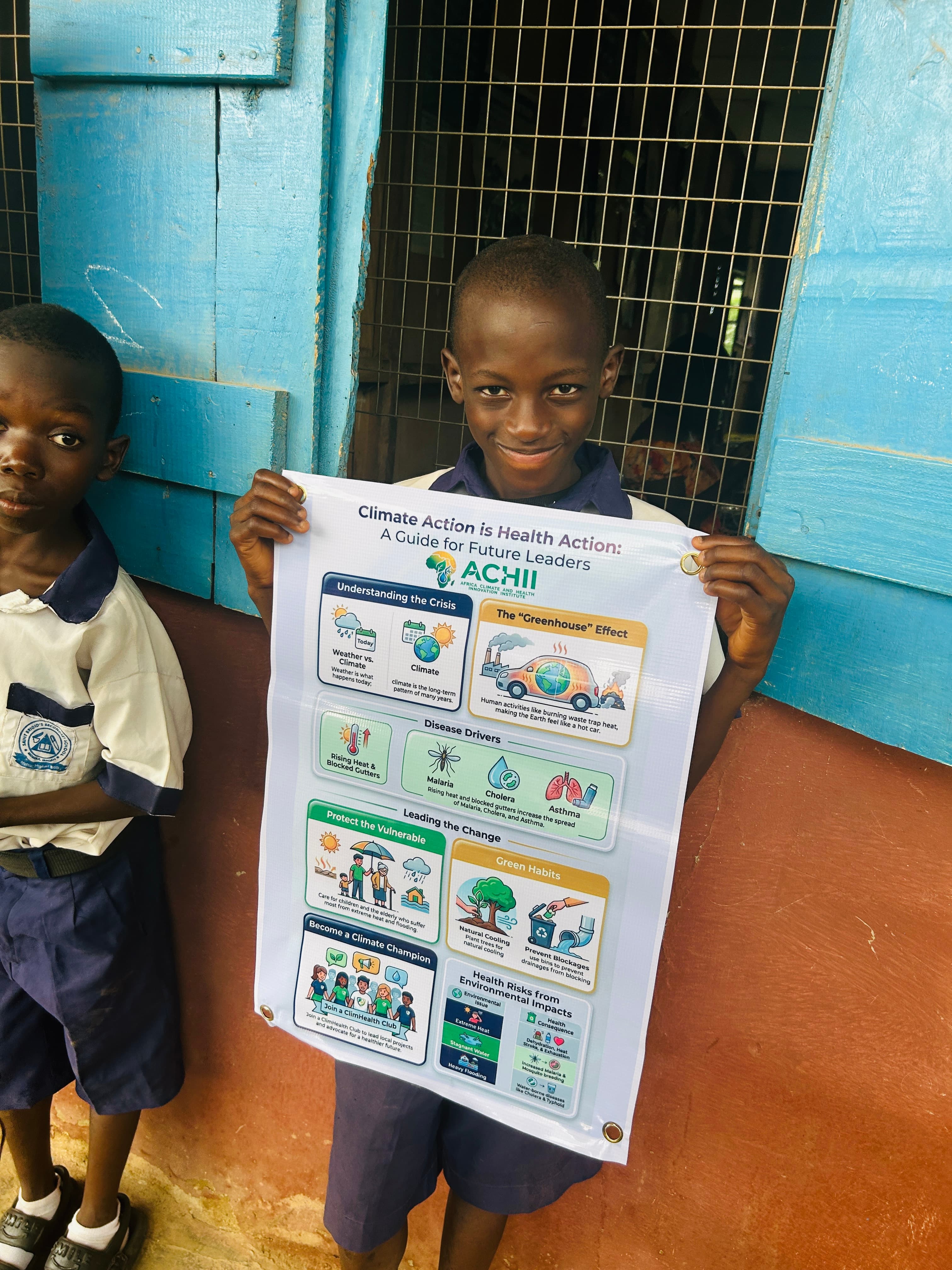 An ACHII volunteer holding a climate-health education poster